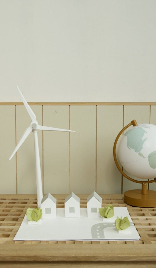 Vertical shot of a school project with miniature windmill and globe, symbolizing renewable energy.